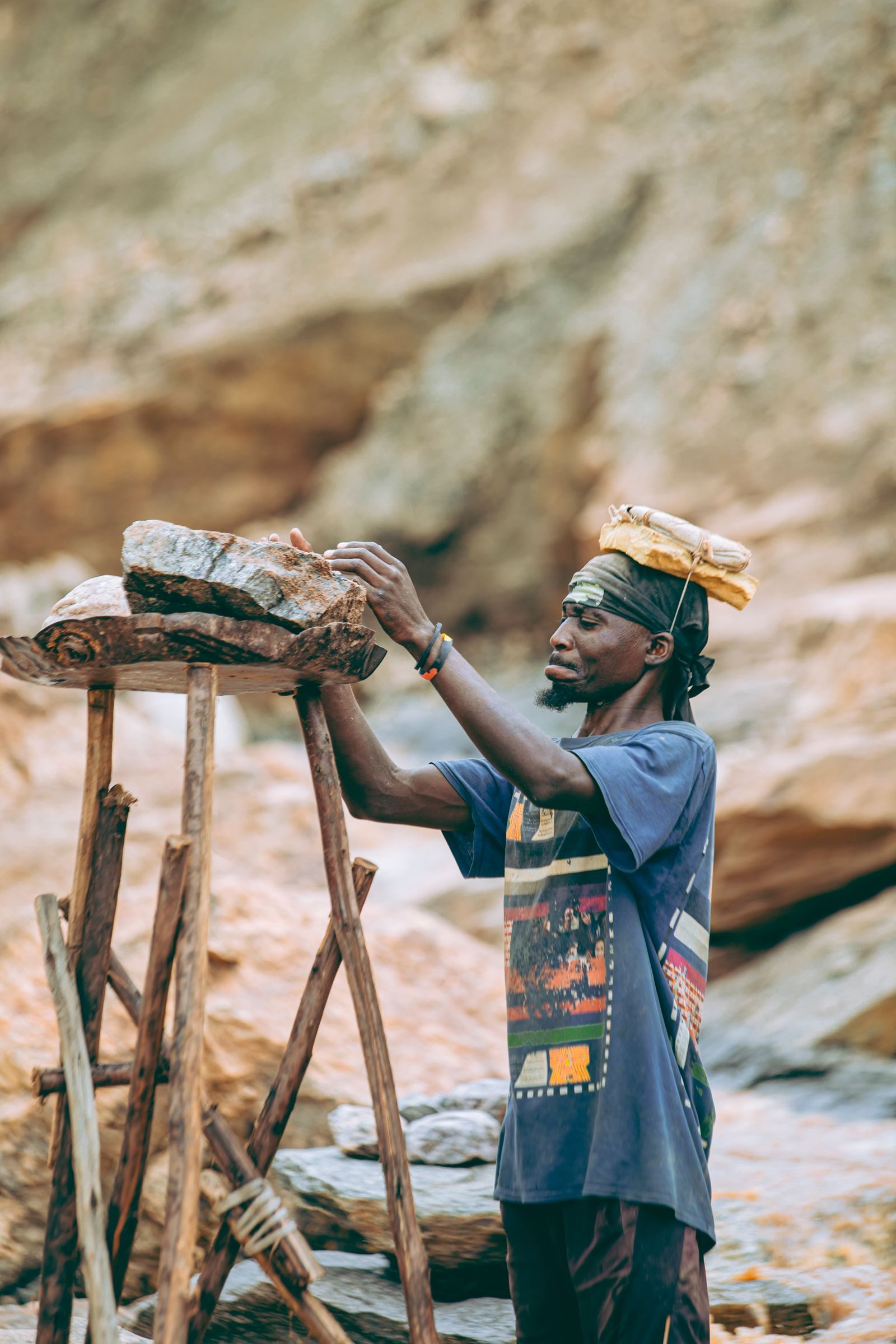Artisanal miner working a rock face at a licensed mining site