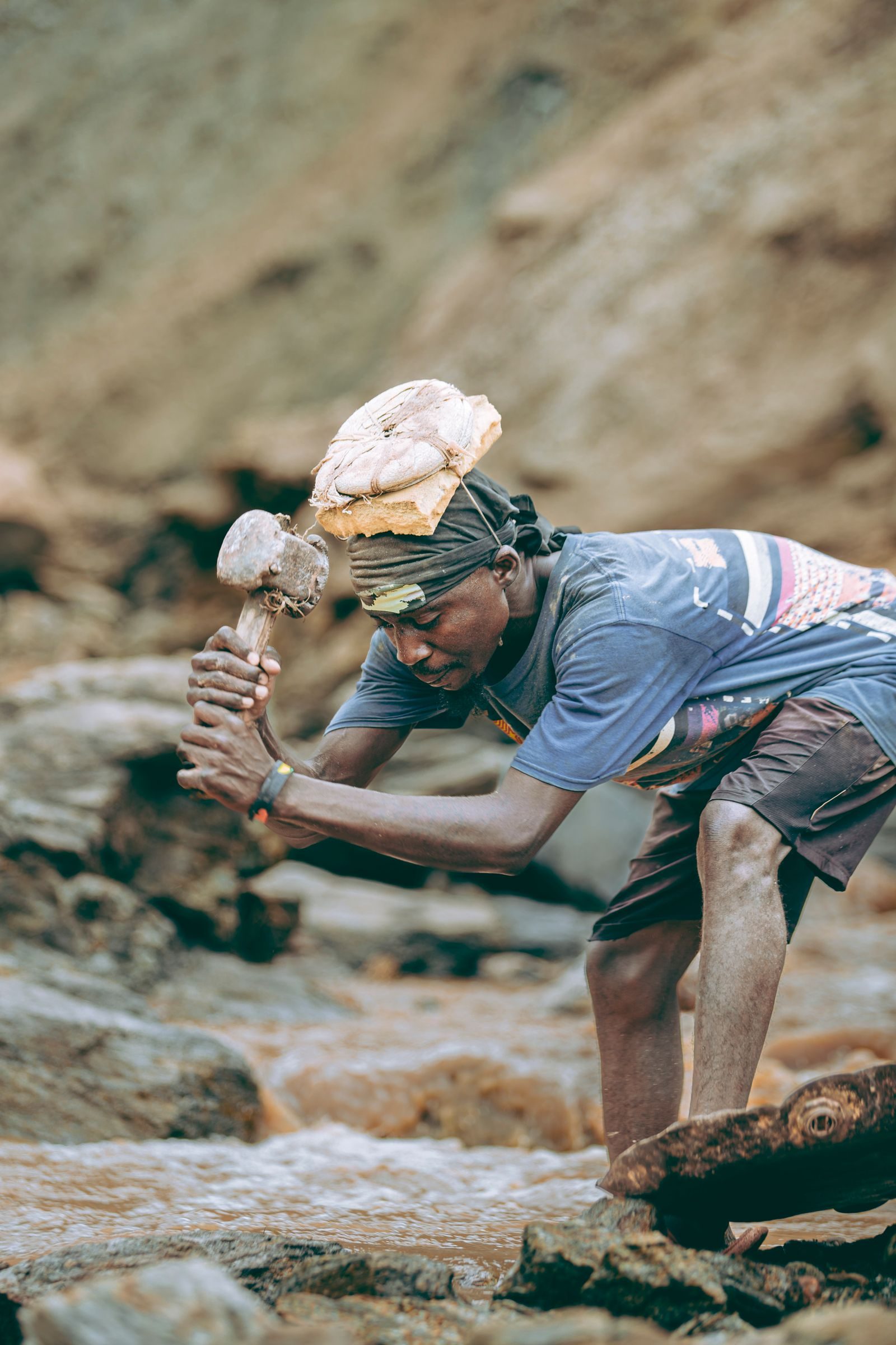 Miner manually breaking rock to extract ore by hand